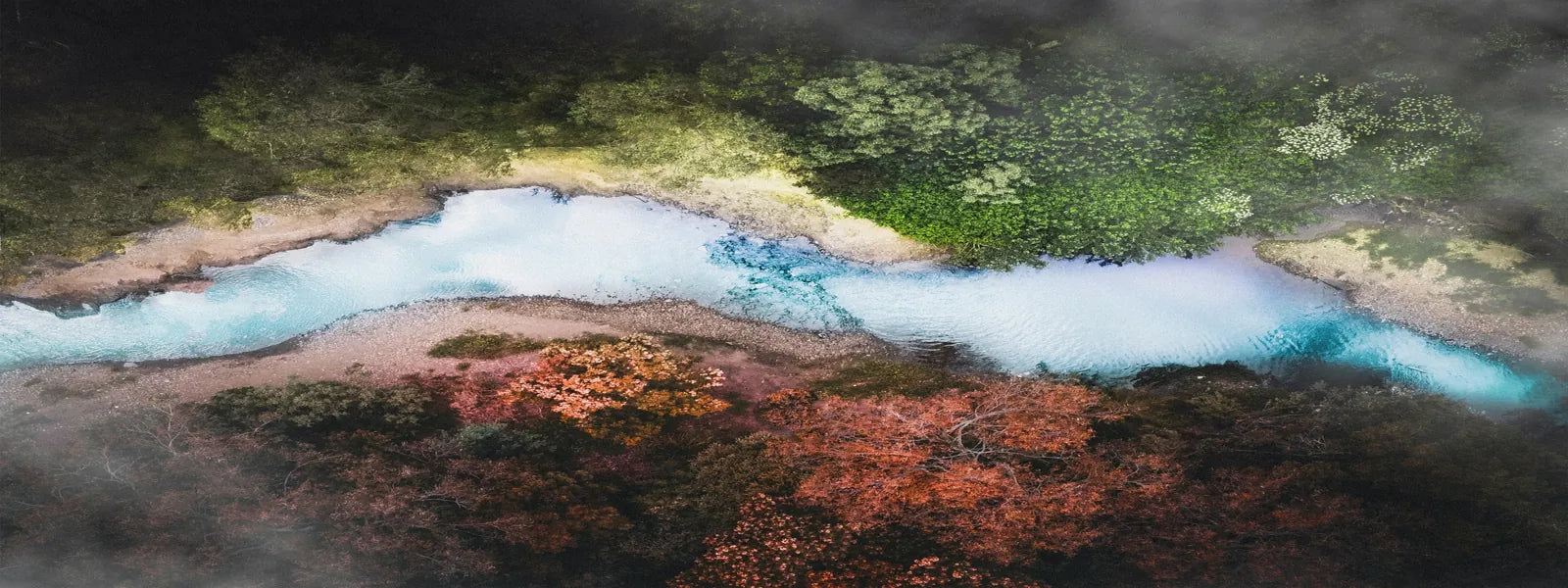 Aerial view of a clean blue river flowing through lush forest, representing eco-friendly living and natural balance
