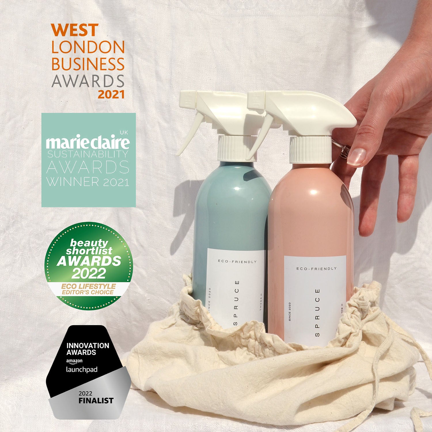 Cleaning sprays in a canvas bag in front of a white sheet with best eco friendly cleaning products award logo