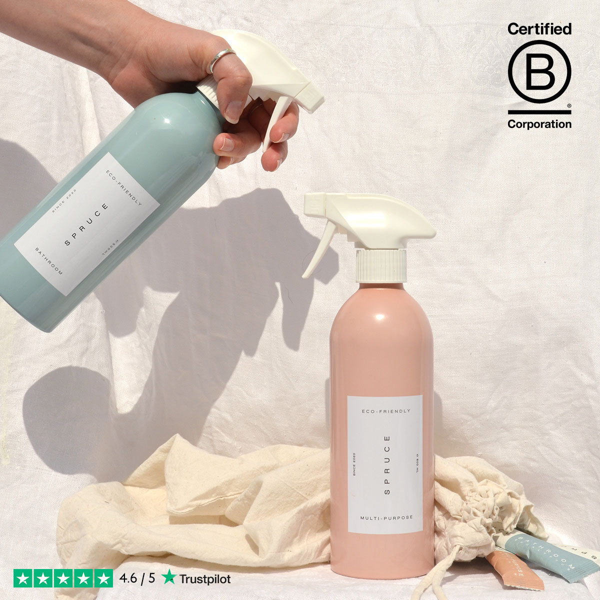 Hand holding eco friendly cleaning products in front of a white sheet