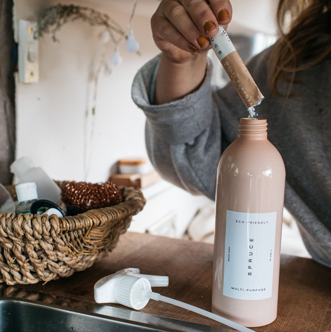 Woman emptying a refill into a surface cleaner spray